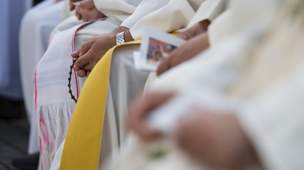A priest prays the rosary