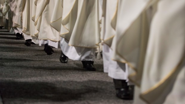 Szereg księży idących w procesji