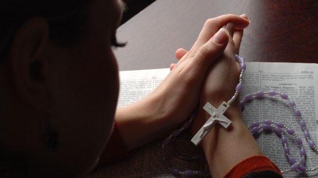 web-woman-praying-rosary-mehmet-alci-shutterstock_10641835