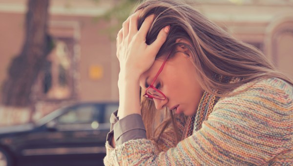 Załamana kobieta trzyma się za głowę