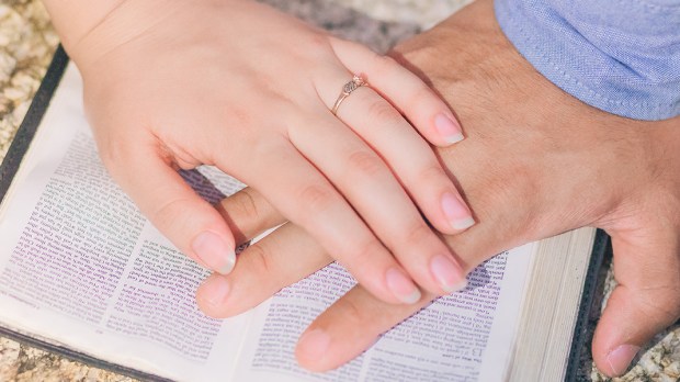 Ręce położone razem na Biblii