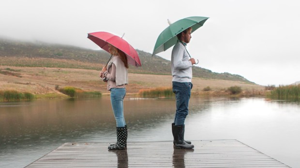 Para z parasolkami stoi nad jeziorem