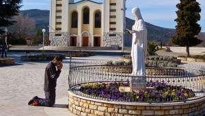 Mężczyzna modli się przed figurą Maryi