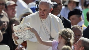 Papież Franciszek z dziewczynką pokazującą swój rysunek