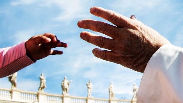 Ręka dziecka i papieża Franciszka