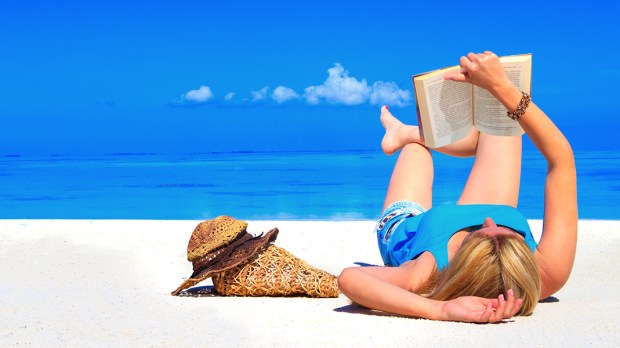 Kobieta czyta książkę na plaży