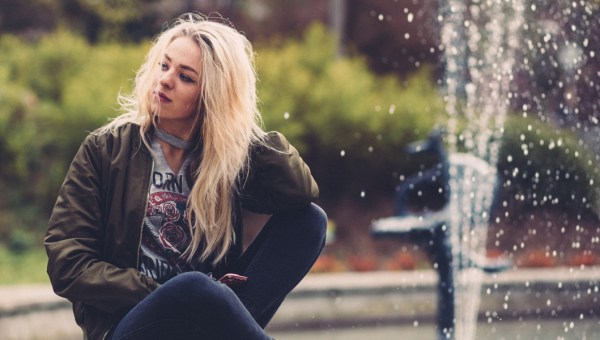 Dziewczyna siedząca na brzegu fontanny