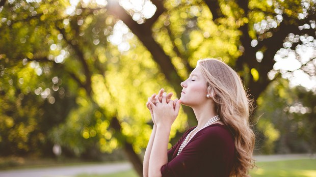Dziewczyna modląca się w parku