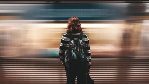 Kobieta stojąca na peronie metra przed przejeżdżającym wagonem