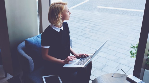 Dziewczyna z laptopem przy pracy w oknie