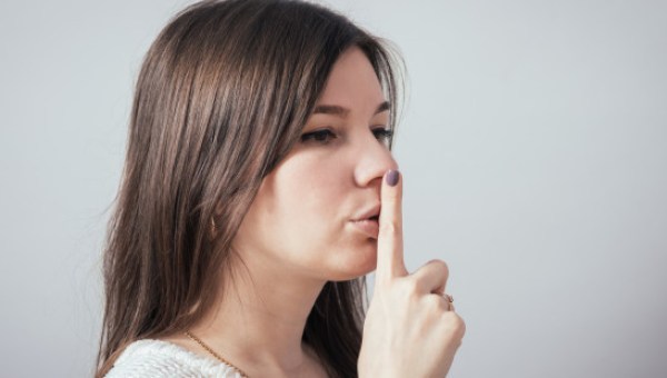 Młoda kobieta ucisza gestem