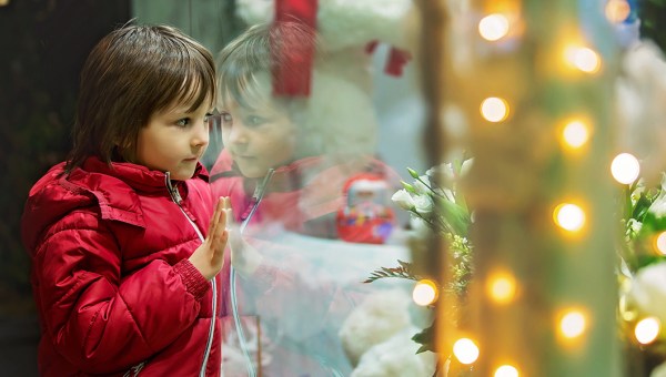 DZIEWCZYNKA PATRZY PRZEZ WITRYNĘ