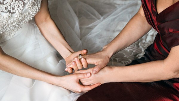 Panna młoda trzyma za ręce starszą od siebie kobietę