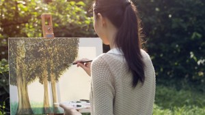 Artystka maluje obraz na zewnątrz