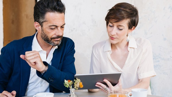 Mężczyzna i kobitea wspólnie przeglądają informacje na tablecie