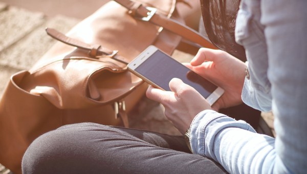 KOBIETA Z TELEFONEM W DŁONIACH