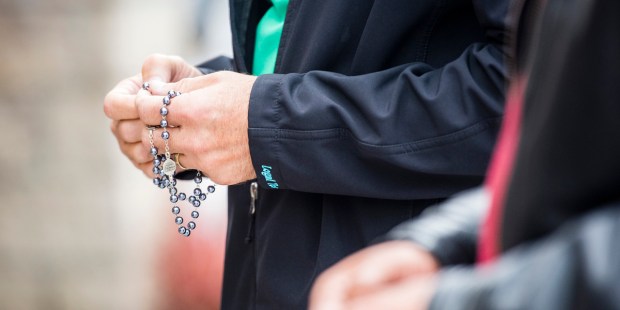 MAN,PRAYING,ROSARY