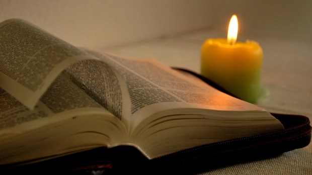 Otwarta Biblia przy świeczce