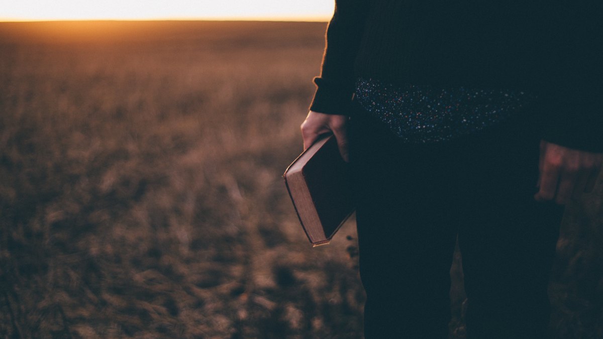 biblia-trzymana-w-reku zachod slonca