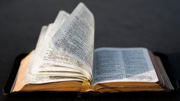 Otwarta Biblia ktorej kartki przewraca wiatr