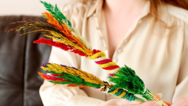 Kobieta trzyma w rękach wielkanocne palmy