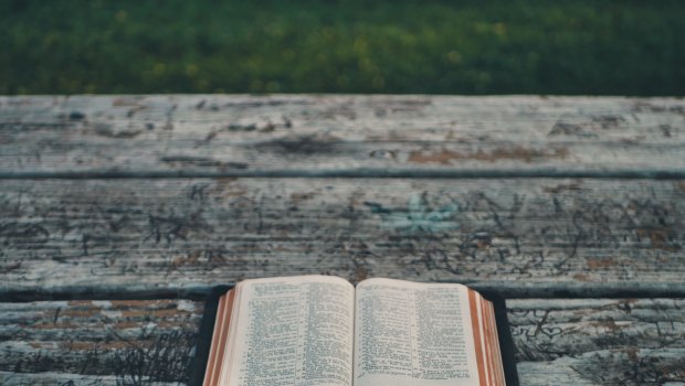 Otwarta Biblia leżąca na deskach