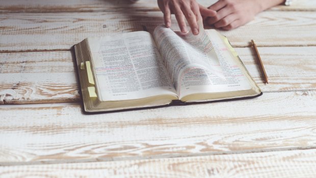 Biblia otwarta na drewnianym stole