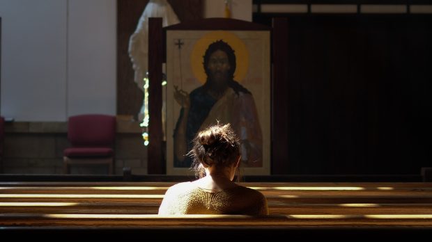 Dziewczyna modlaca sie przed ikona
