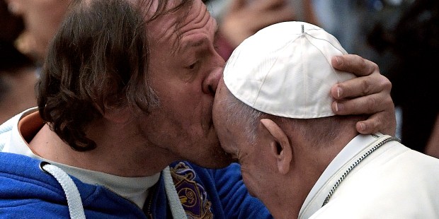 Pope Francis is kissed by a person