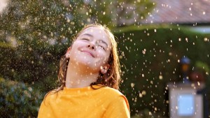 WEB3-Happy-smiling-teenage-girl-enjoying-rain-and-sun-putting-her-face-under-water-drops-Shutterstock_1542223286.jpg