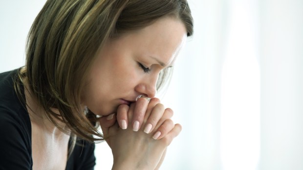 Kobieta przeżywająca kryzys modli się do Boga