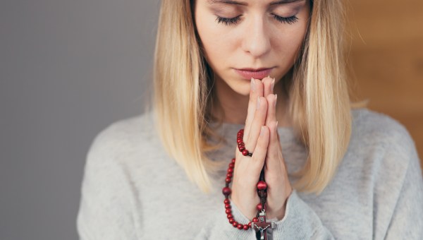 Kobieta modli się na różańcu