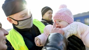 Policjant trzyma dziewczynkę z Ukrainy