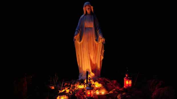 statue of a virgin mary lighted by candles