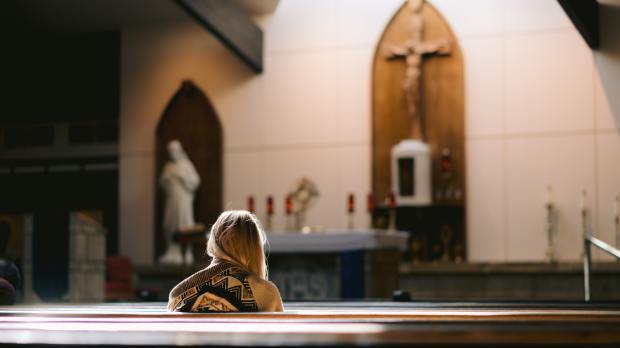 młoda kobieta modli się w kościele