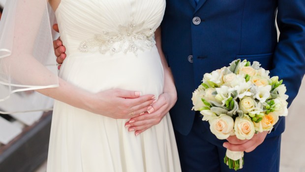 panna młody w ciąży stoi z panem młodym