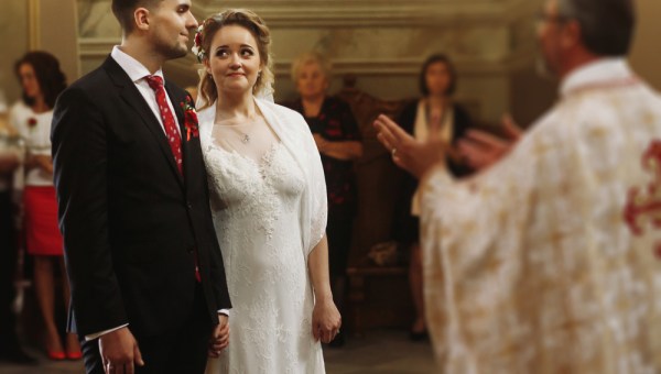 Para młoda słucha słów księdza podczas ceremonii ślubnej