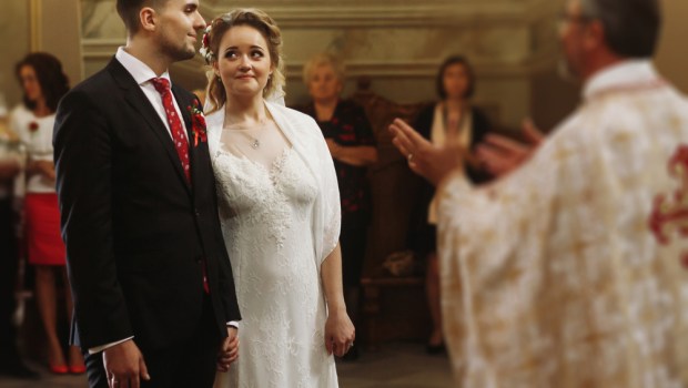 Para młoda słucha słów księdza podczas ceremonii ślubnej