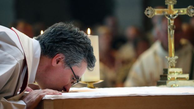 ksiądz całuje ołtarz podczas Mszy świętej