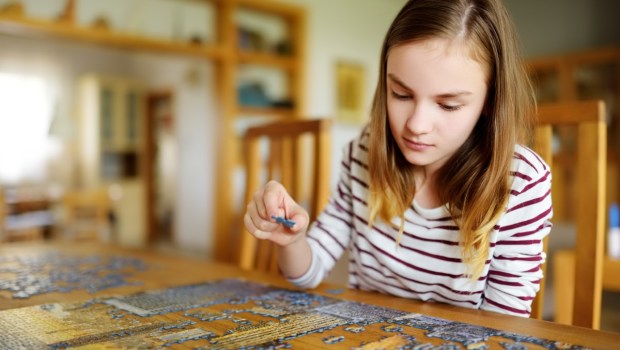 dziewczyna ćwiczy cierpliwość, układając puzzle