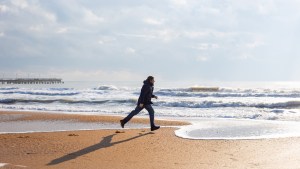 mężczyzna spaceruje nad brzegiem morza