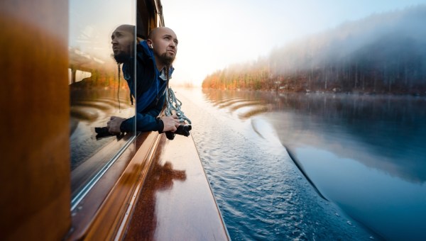 mężczyzna płynie łodzią i spogląda na jezioro