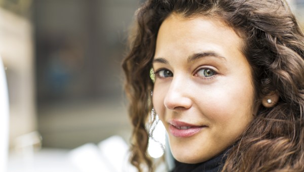 uśmiechnięta delikatnie kobieta patrzy wprost w obiektyw