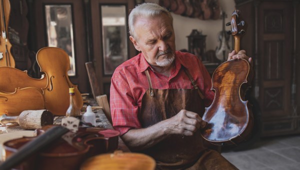 ludwisarz czyści skrzypce, nad którymi pracuje