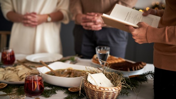 kolacja wigilijna, jedna z osób prowadzi modlitwę