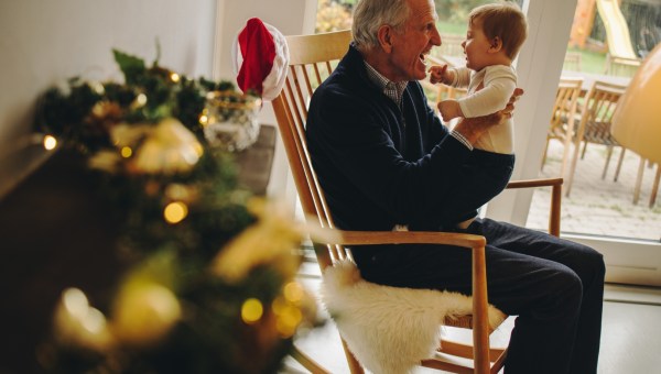 dziadek bawi się z kilkumiesięcznym wnukiem w scenerii bożonarodzeniowej