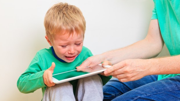 uzależnione od tableta dziecko płacze, kiedy ojciec próbuje mu go zabrać