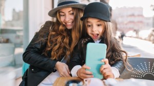 Młoda mama i jej mała córeczka robią sobie selfie smartfonem