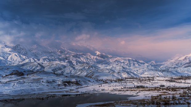 View of the lake and snowy mountains shrouded in clouds
