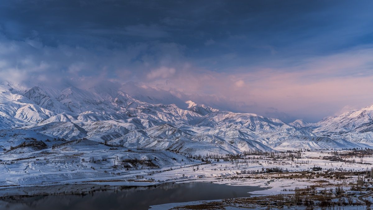 View of the lake and snowy mountains shrouded in clouds